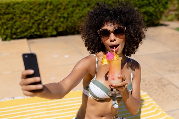 Giovane donna che prende selfie vicino alla piscina