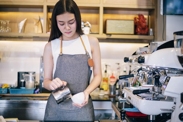 Giovane donna che prepara il caffè in un caffè