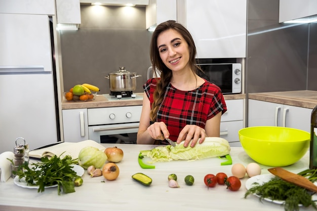 Giovane donna che prepara la cena in cucina. uno stile di vita sano.