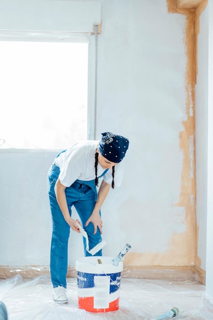 Giovane donna che prepara pittura per la pittura a casa.