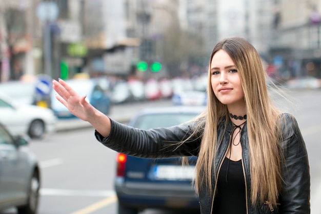 Giovane donna che prova a prendere un taxi