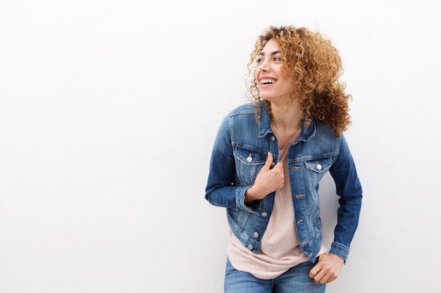 Giovane donna che ride con la giacca di jeans su sfondo bianco