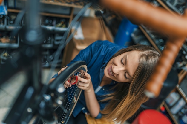 Giovane donna che ripara bicicletta