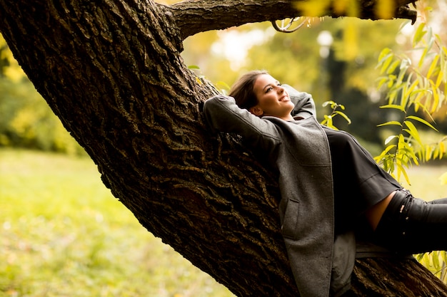 Giovane donna che riposa sull&#39;albero