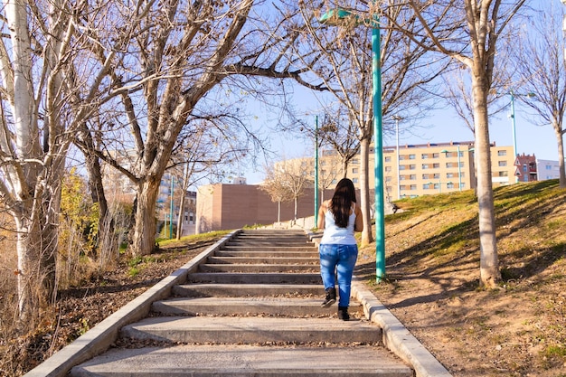 Giovane donna che sale le scale in un parco