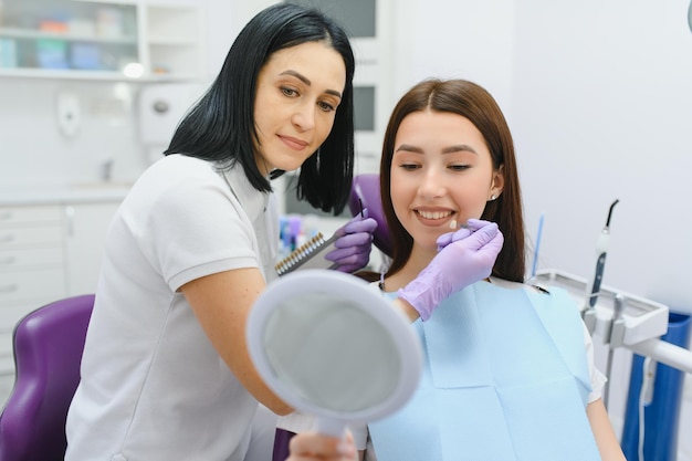 Giovane donna che sceglie il colore dei denti dal dentista