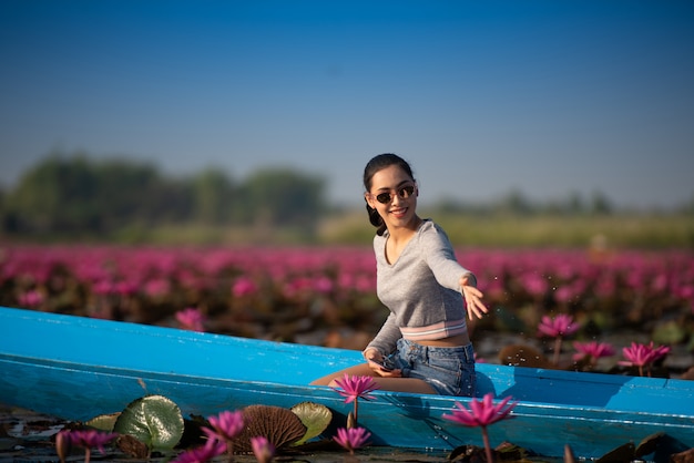 Giovane donna che si distende con il bellissimo campo di fiori di loto al Mar Rosso Lotus