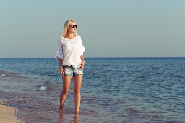 Giovane donna che si distende sulla spiaggia