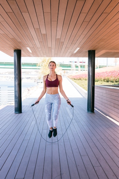 Giovane donna che si esercita facendo uso del salto della corda nella forma fisica