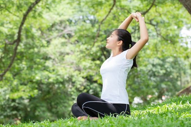 Giovane donna che si estende nel parco naturale. concetti di salute.