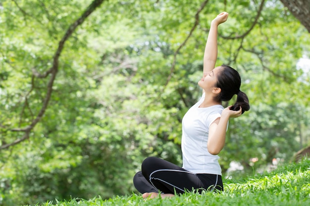 Giovane donna che si estende nel parco naturale. concetti di salute.