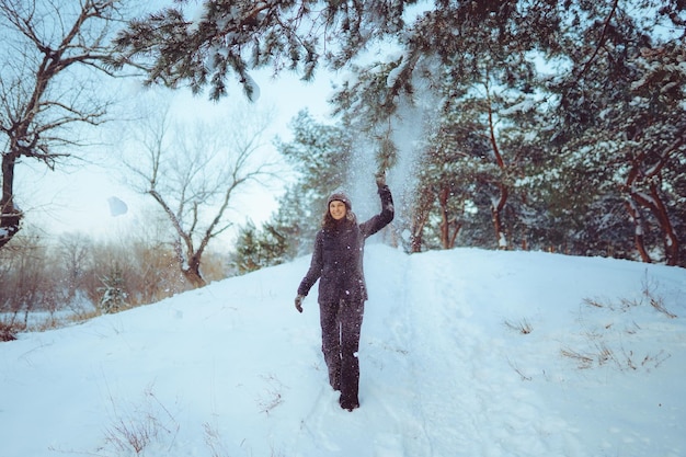 Giovane donna che si gode il tempo invernale nella foresta innevata tempo freddo vacanze invernali