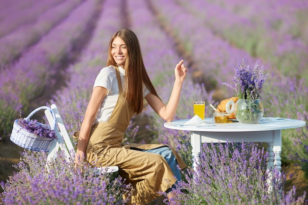 Giovane donna che si gode la cena in un campo di lavanda