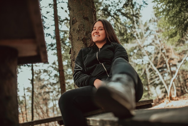 Giovane donna che si gode la natura facendo un picnic nella natura che cammina nella foresta godendosi il tramonto