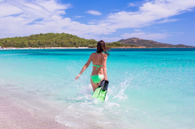 Giovane donna che si imbatte in mare blu tropicale con attrezzatura per lo snorkeling