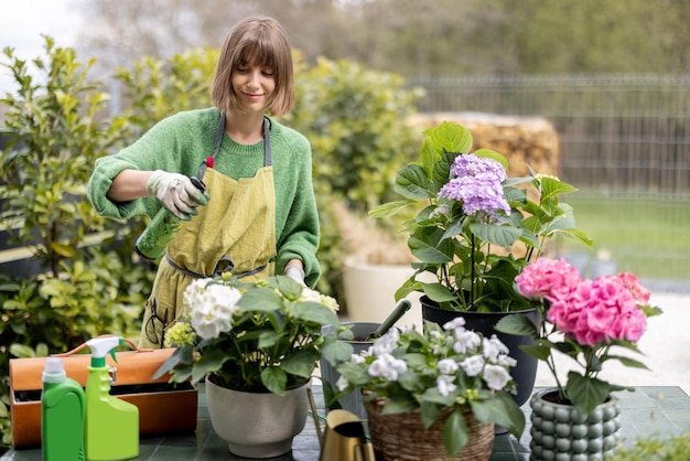 Giovane donna che si prende cura dei fiori in giardino