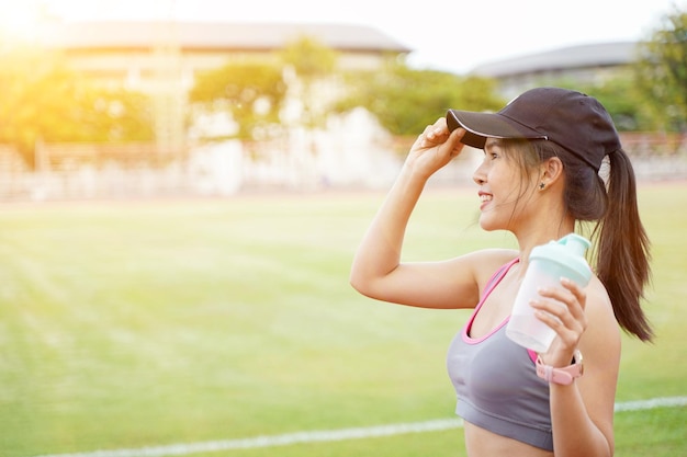 Giovane donna che si rilassa dopo l'allenamento fitness allo stadio di calcio Ha un bel sorriso