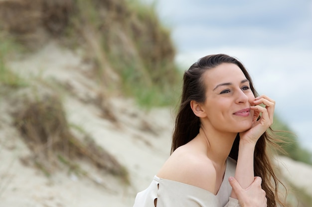 Giovane donna che si siede all&#39;aperto pensando