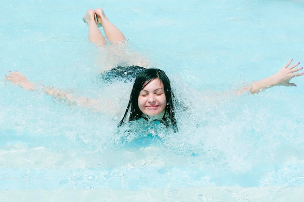 Giovane donna che sorride in una piscina