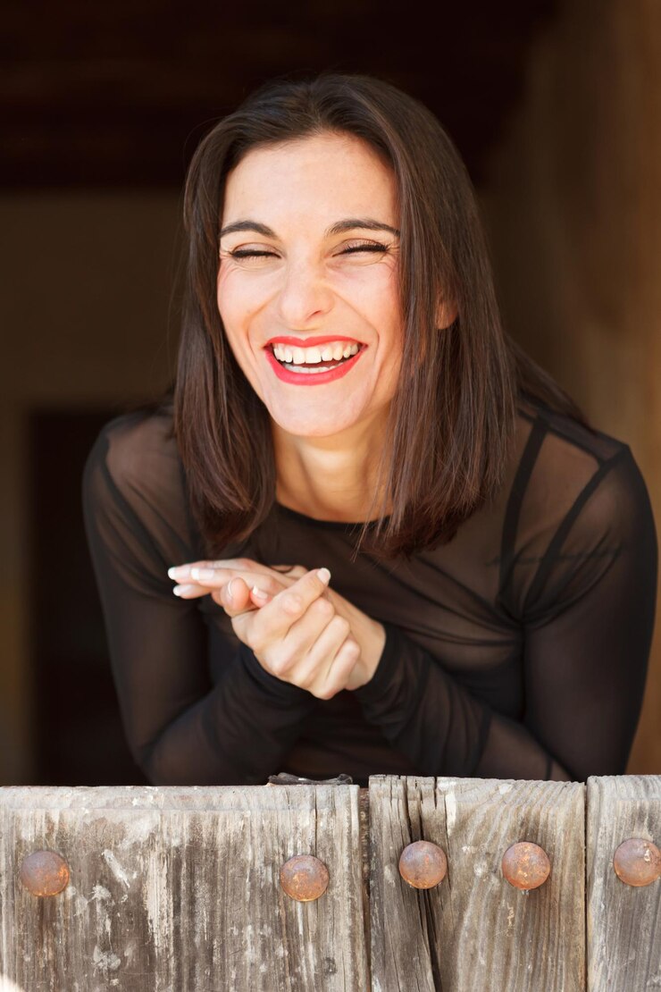 Foto giovane donna che sorride seduta sul legno