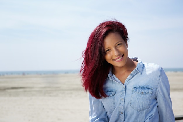 Giovane donna che sorride sulla spiaggia