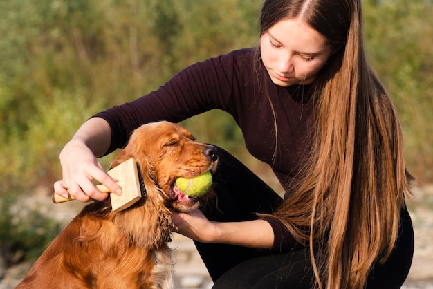 Giovane donna che spazzola un cocker spaniel