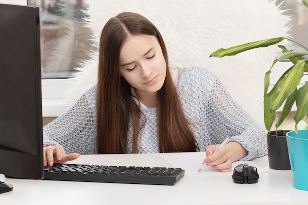 Giovane donna che studia a casa al computer durante la quarantena