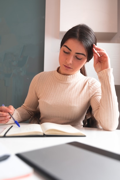 Giovane donna che studia a casa