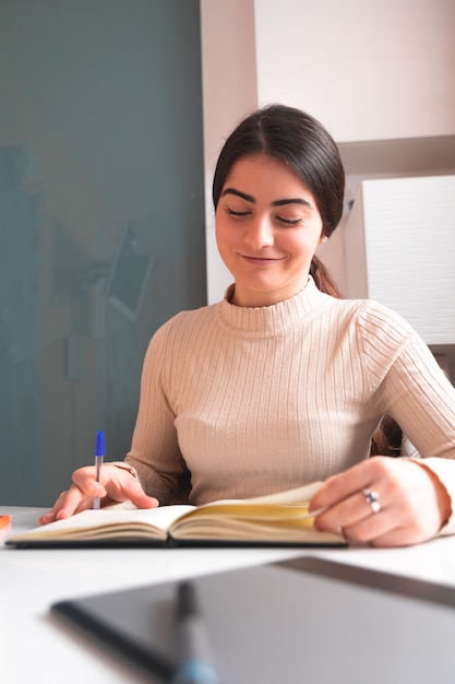 Giovane donna che studia a casa