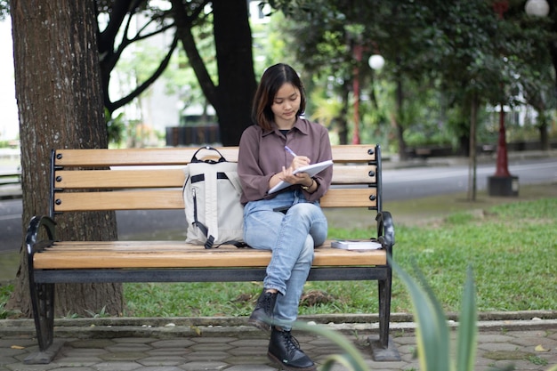 Giovane donna che studia al parco