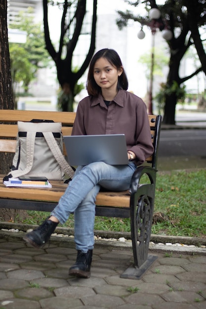 Giovane donna che studia al parco