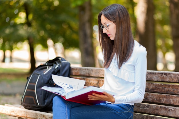 Giovane donna che studia al parco