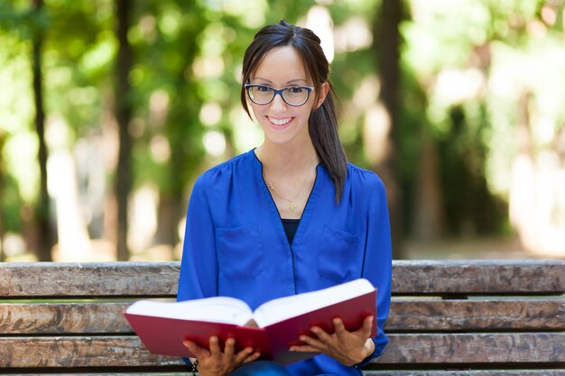 Giovane donna che studia al parco