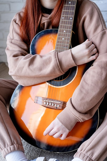 Giovane donna che suona la chitarra a casa