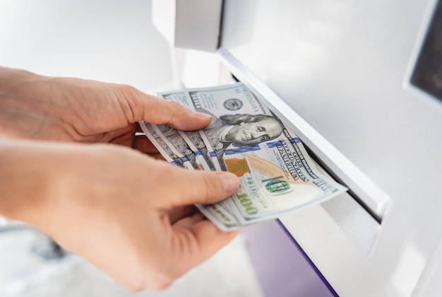 Giovane donna che tiene i soldi in mano dopo aver ritirato i contanti al bancomat