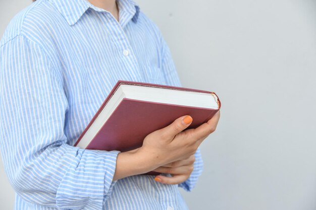 Giovane donna che tiene il libro tra le mani con spazio per il testo Concetto di giornata scolastica