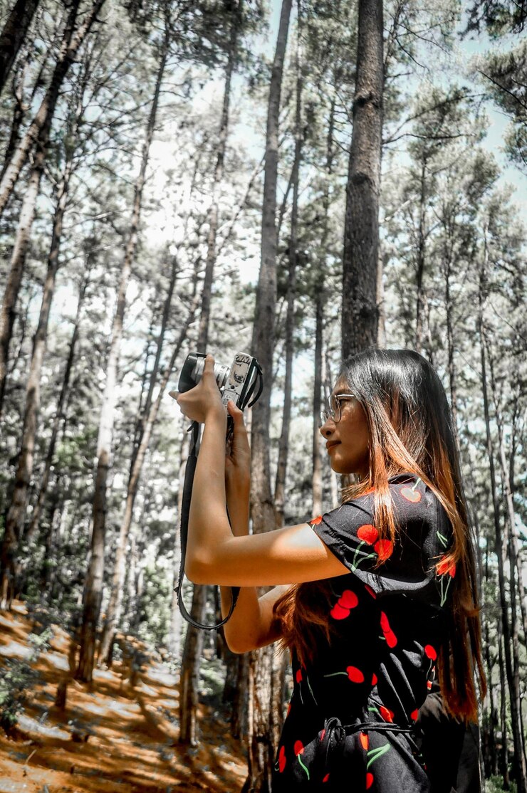 Foto giovane donna che tiene il tronco di un albero nella foresta