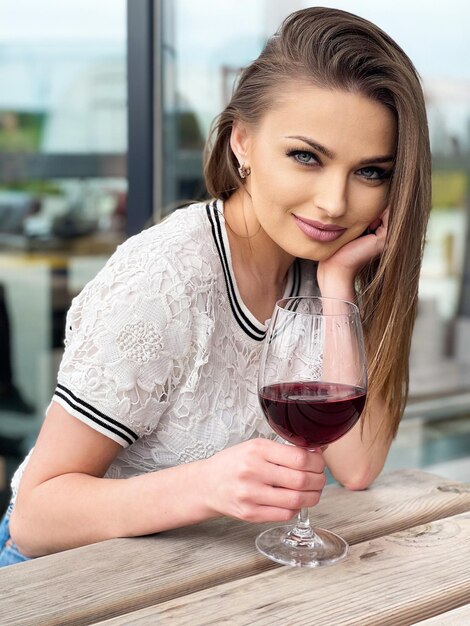Giovane donna che tiene un bicchiere di vino rosso