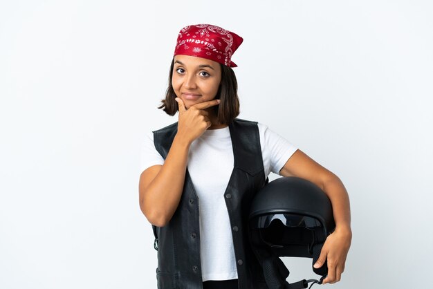 Giovane donna che tiene un casco del motociclo isolato sul pensiero bianco