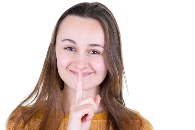 Giovane donna che tiene un dito sulle labbra in un gesto silenzioso