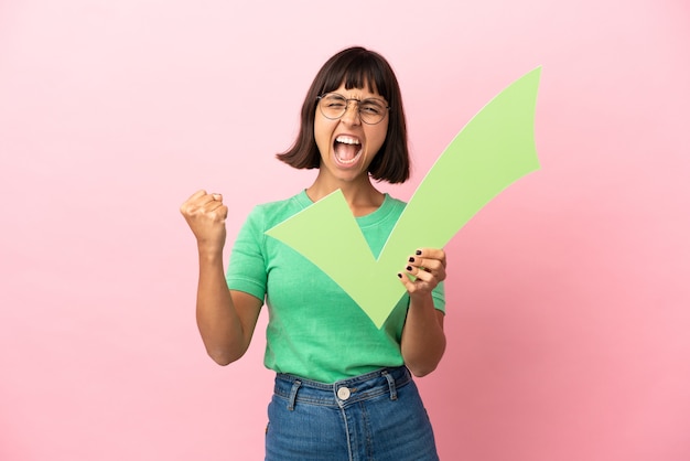 Giovane donna che tiene un'icona di controllo e celebra una vittoria