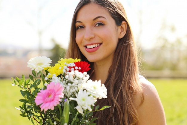 Giovane donna che tiene un mazzo di fiori