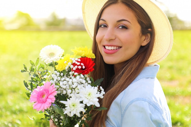 Giovane donna che tiene un mazzo di fiori