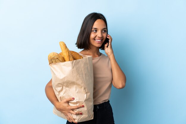 Giovane donna che tiene un sacchetto di carta con il pane