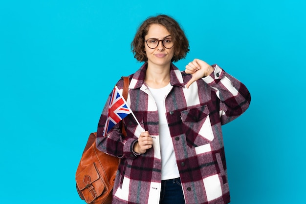 Giovane donna che tiene una bandiera del Regno Unito isolata