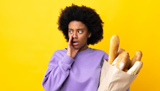 Giovane donna che tiene una borsa con il pane