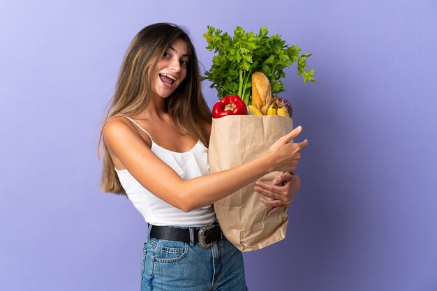 Giovane donna che tiene una borsa della spesa