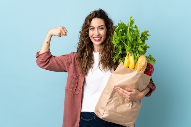 Giovane donna che tiene una borsa della spesa