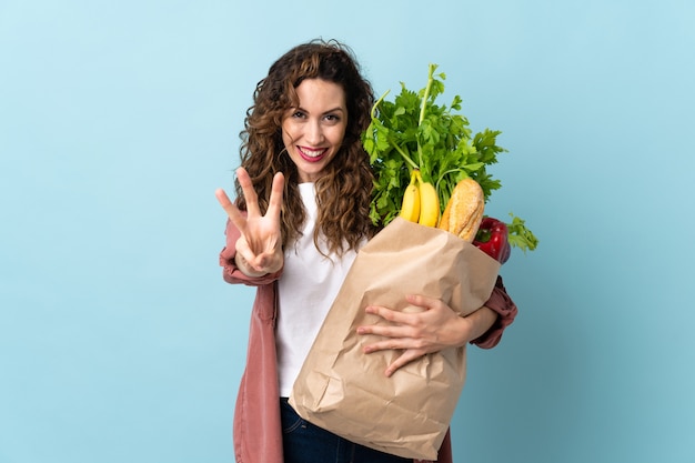 Giovane donna che tiene una borsa della spesa