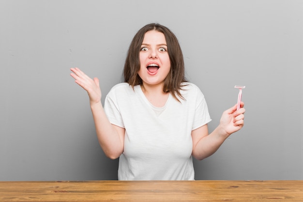 Giovane donna che tiene una lametta che celebra una vittoria